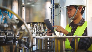 Man with Tablet inspecting industrial machinery 