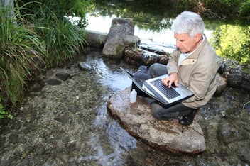 Man monitoring water quality with laptop